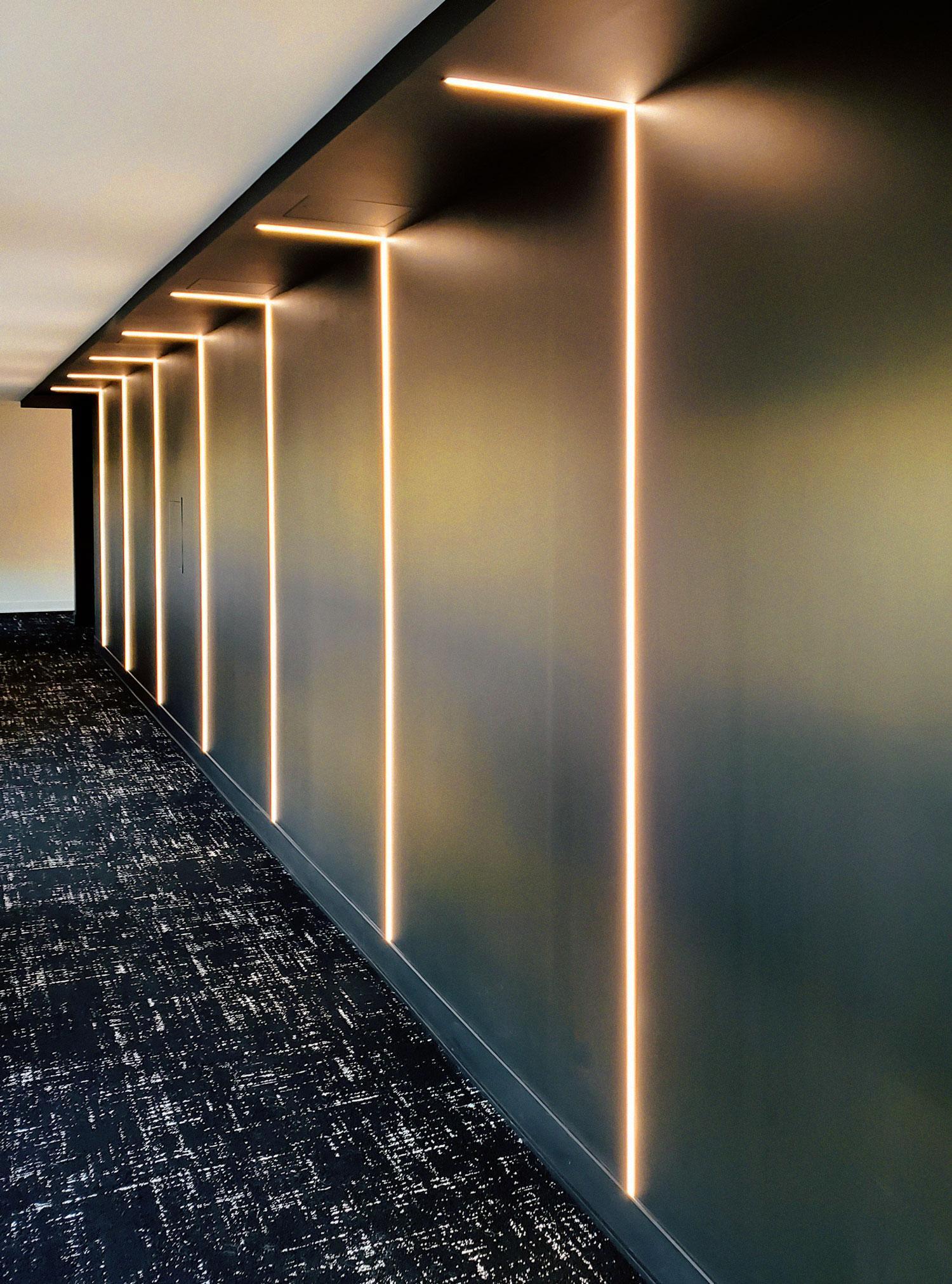 An office hall with recessed LED linear lighting.